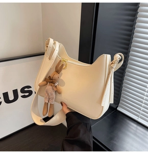 Detailed view of hobo bag with wide shoulder strap and cute rabbit plush charm