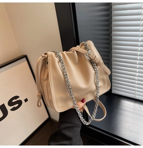 Dettaglio borsa a secchiello in pelle beige plissettata con catena argento e coulisse