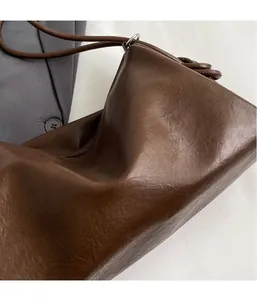 Close-up of dark brown Boston bag showing high-quality leather texture and strap