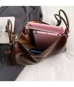 Detail view of deep brown leather bag interior showing large capacity and tablet storage