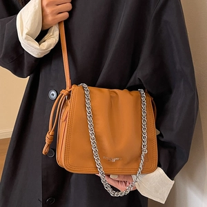 Borsa a secchiello arricciata marrone con catena argento e tracolla in pelle su modella