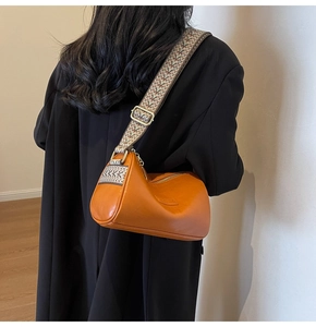 Detail of caramel crescent shoulder bag with a wide ethnic style patterned strap