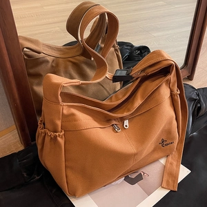 Large orange canvas crossbody bag with dual zippers and wide shoulder strap for commuting