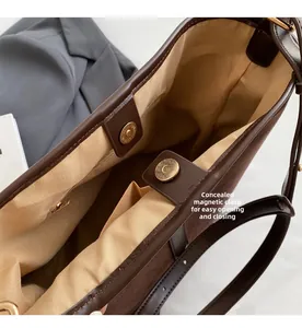 Detail of internal magnetic buckle closure and inner pocket on brown leather bucket bag