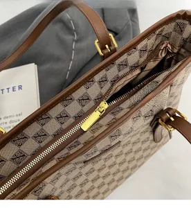 Detailed close-up of golden zipper and textured checkered pattern on large tote bag