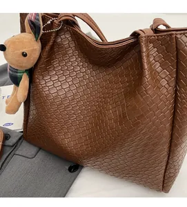 Detailed close-up of brown woven tote bag texture with cute plush bunny charm