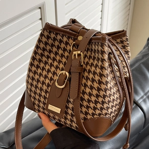 Chic houndstooth bucket bag with brown leather trim and golden metal clasp for women