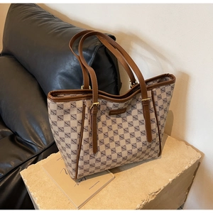 Detailed view of the checkered canvas texture and leather strap with golden buckle