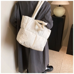Dettaglio di una borsa tote trapuntata bianca su una modella in uno studio accogliente