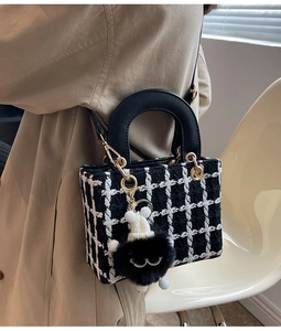 Dettaglio mini borsa in tweed a scacchi con ciondolo mostro di peluche e manici neri