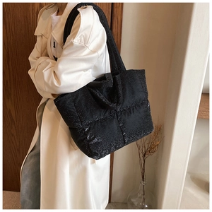 Dettaglio di una grande borsa tote trapuntata nera con finitura glitter e tracolla larga