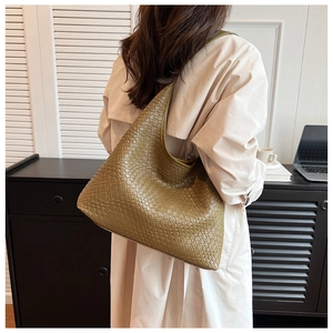 Detail of the large olive hobo bag showing the intricate woven leather texture in a daily setting