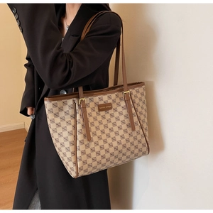 Detail showing checkered tote bag with brown leather straps and adjustable buckles