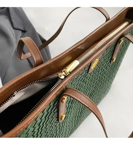 Détail du sac cabas tissé avec ferrures dorées, fermeture éclair et logo gravé