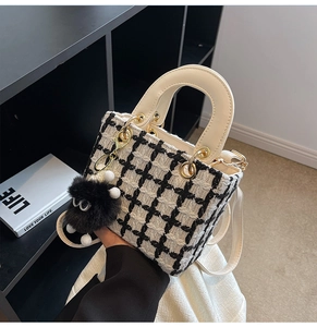 Dettaglio borsa tote in tweed a scacchi con tracolla in pelle e ciondolo occhio