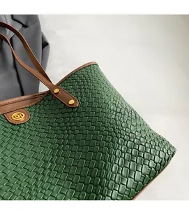 Détail du cabas tissé vert avec anses en cuir marron et finitions en métal doré