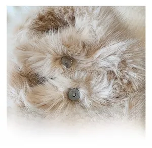 Detail view of cylinder magnetic buckles on soft light brown faux fur texture