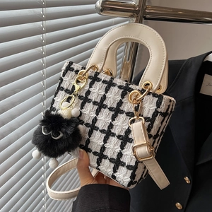 Borsa a mano chic in tweed a quadri bianchi e neri con tracolla e ciondolo a pompon