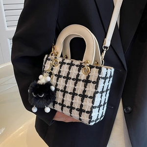 Elegante borsa a mano in tweed scozzese bianco e nero con ciondolo e tracolla regolabile