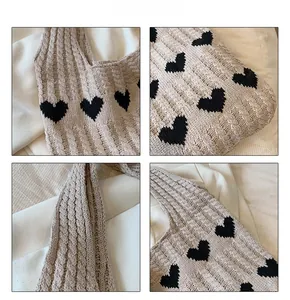 Gros plan détaillé sur la texture en maille torsadée et le motif cœur noir du sac beige