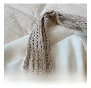 Gros plan détaillé de la poignée beige du sac en maille avec motif de tresse doux