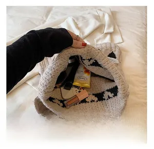 Intérieur spacieux du sac cabas en tricot montrant le rangement pour téléphone et maquillage