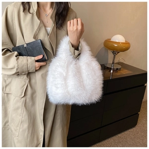 Detail of soft white faux fur handbag texture held by model wearing a khaki coat