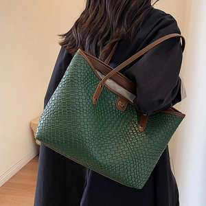 Grand sac cabas tressé vert foncé avec anses marron porté à l'épaule pour le quotidien