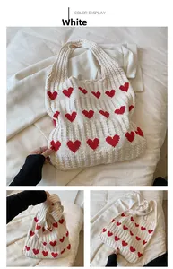 Détail d'un sac fourre-tout en tricot crème avec motifs de cœurs rouges et maille ajourée