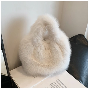 Detail of soft white faux fur plush handbag texture resting on an open book