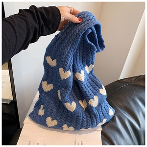 Gros plan détaillé du sac cabas en tricot bleu avec texture douce et motif de cœur