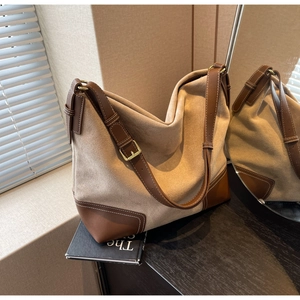 Detail of khaki suede and brown leather tote bag with white contrast stitching