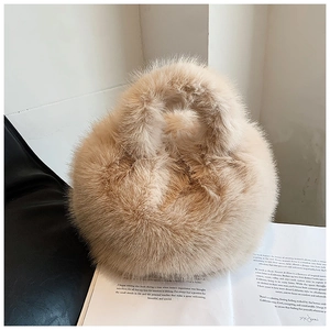 Close-up of soft faux fur handbag in light brown placed on an open lifestyle book