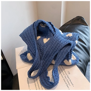 Vue détaillée du sac cabas tricoté bleu avec cœurs blancs et texture torsadée