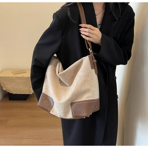 Detail of large tote bag showing beige suede and brown leather contrast stitching