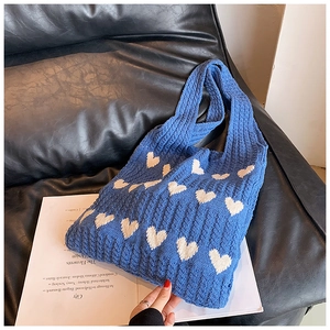 Détail du motif cœur sur un grand sac cabas en tricot de coton bleu et blanc doux