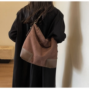 Detail of large brown suede tote bag with leather corner patches and contrast stitching