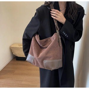 Detail of dark coffee tote bag with white contrast stitching and suede texture