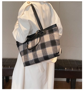 Detailed view of checkered tote bag worn over the shoulder showing large capacity
