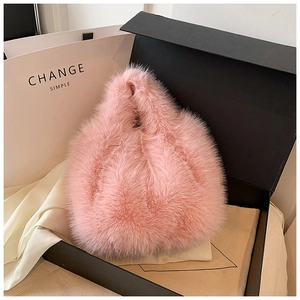 Close-up of pink faux fur handbag on silk fabric and premium gift box set