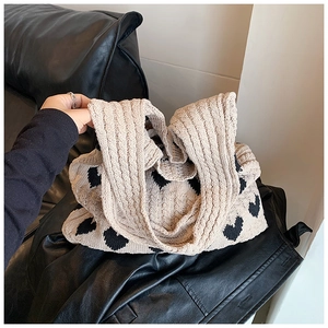 Détail du sac cabas en tricot crème avec motifs de cœurs noirs et texture épaisse