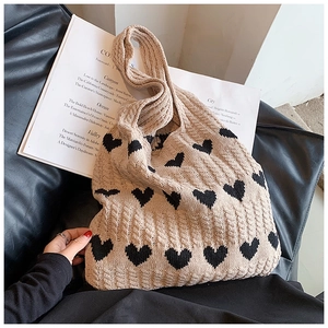 Vue détaillée du sac cabas tricoté beige à cœurs montrant la texture épaisse du fil de coton