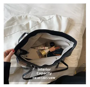 Detail view of the spacious internal capacity of the plaid tote bag with cosmetics