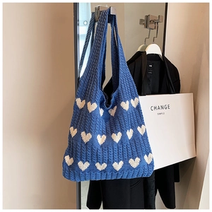 Détail du tissu tricoté du sac fourre-tout bleu à motifs de cœurs sur crochet