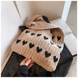 Gros plan détaillé du sac cabas en maille avec motifs de cœurs noirs et texture douce