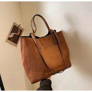 Detailed view of caramel brown suede tote bag with front pocket and slim shoulder straps