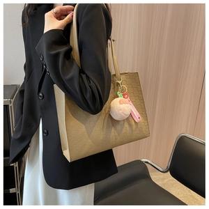 Detail of checkered embossed tote bag with a cute plush charm for daily commuting