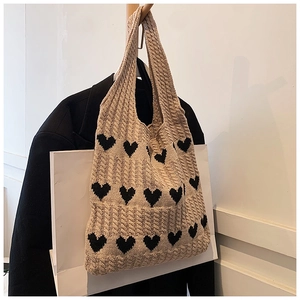 Détail d'un sac cabas en maille beige avec jacquard coeur noir et texture coton doux