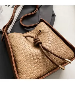 Close-up of woven leather bucket bag texture with drawstring and metal hardware