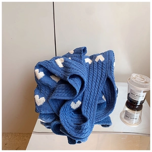 Vue détaillée de la texture du sac cabas en tricot bleu avec motif cœur en coton
